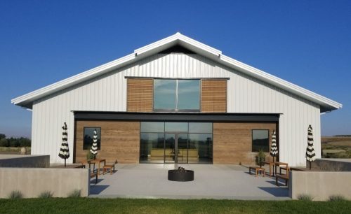 Our design for Revelry Vintners features overhead doors, an attractive commercial storefront opening, and an elegant self-supported mezzanine.